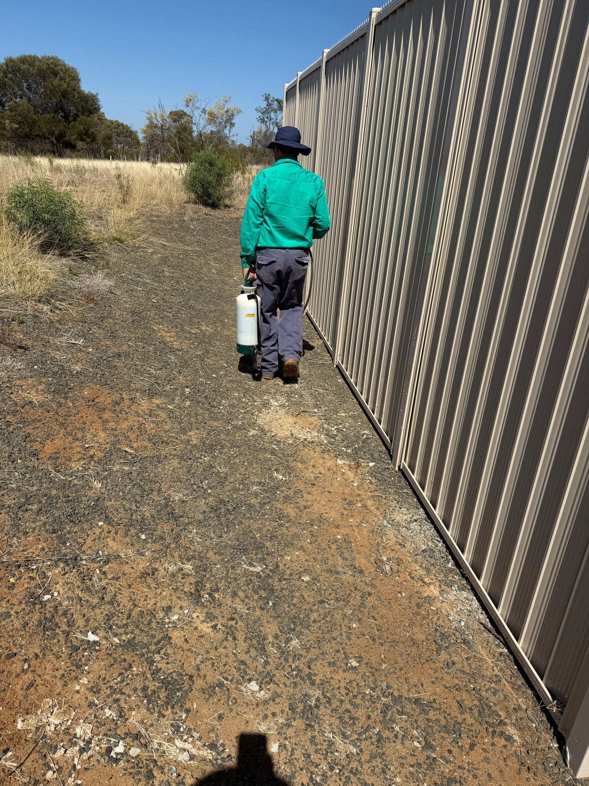 Commercial weed control spraying along fence line